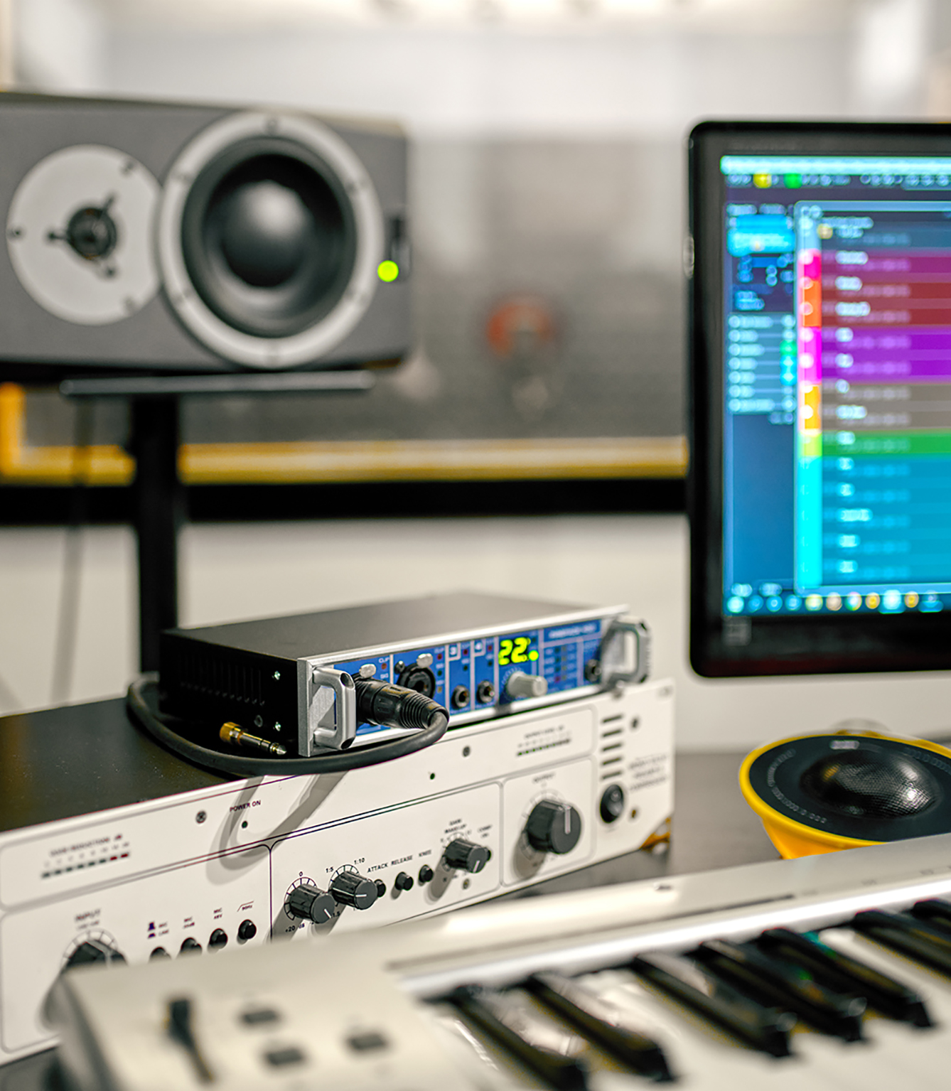 Synthesizer closeup, recording studio equipment on background. Audio speakers, mixer and monitor, sound engineer workplace